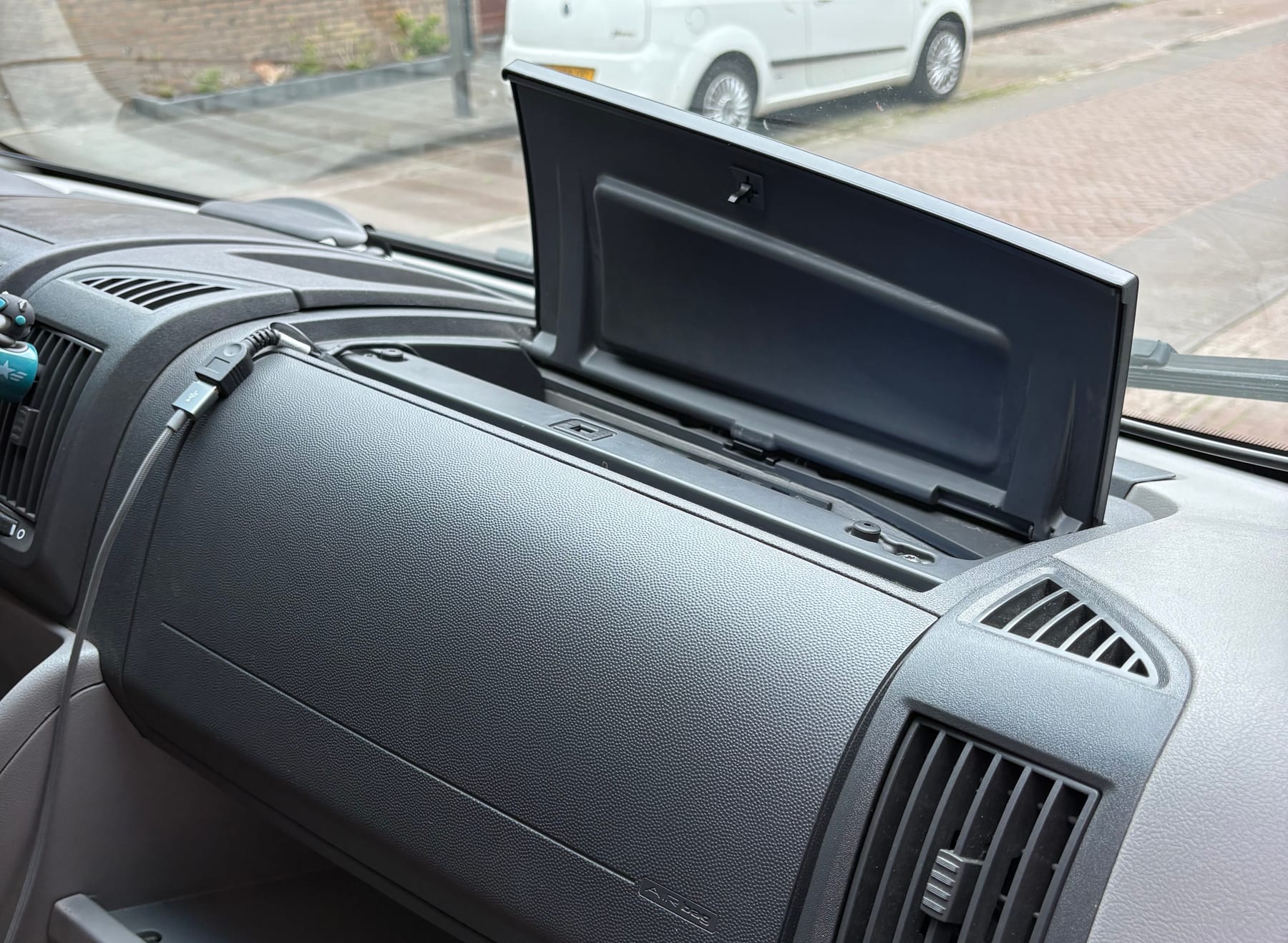 Klepje op het dashboard aan de bijrijderskant waar de rode omvormersleutel ligt.