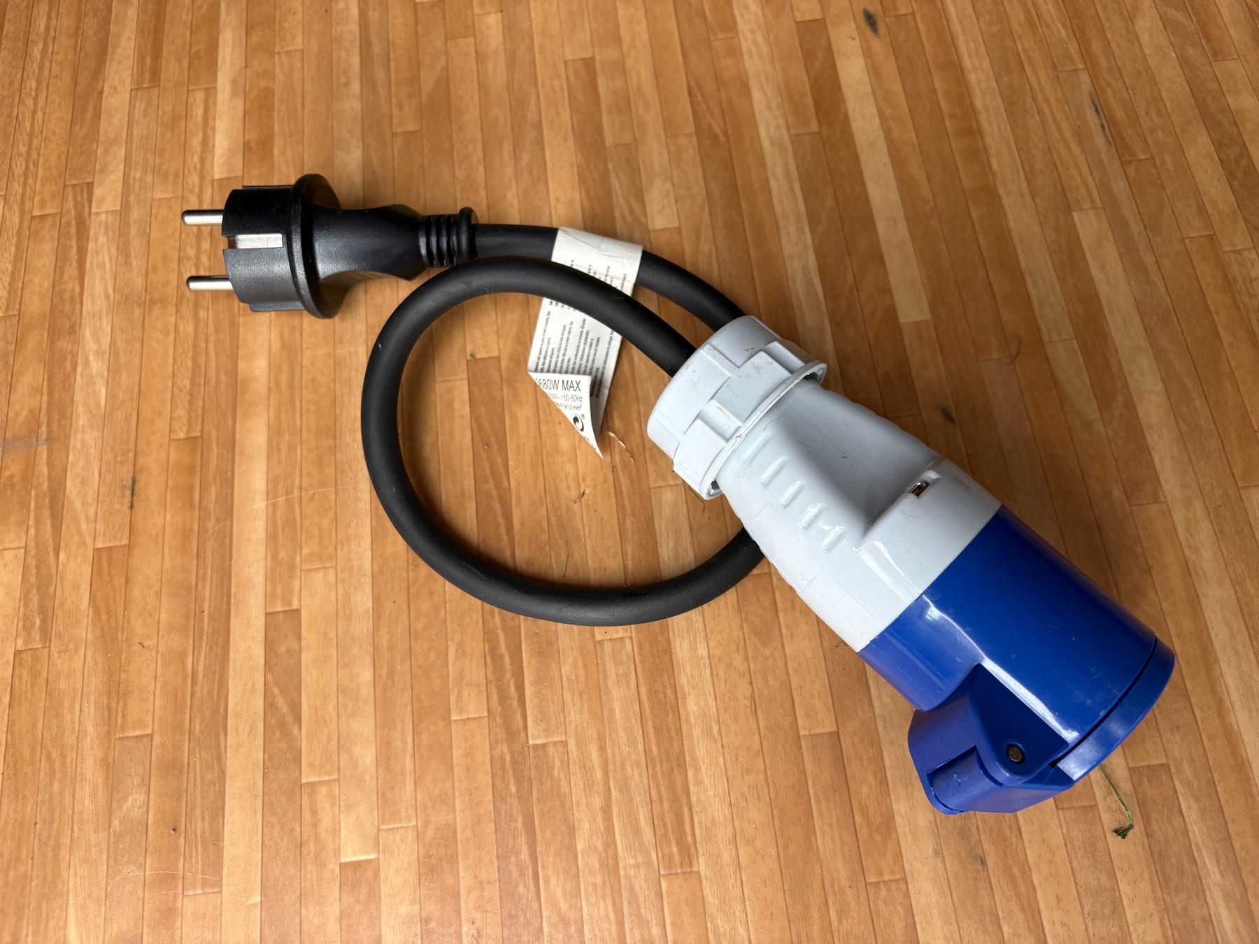 Adapter van een Nederlands stopcontact naar een blauwe campingstekker.