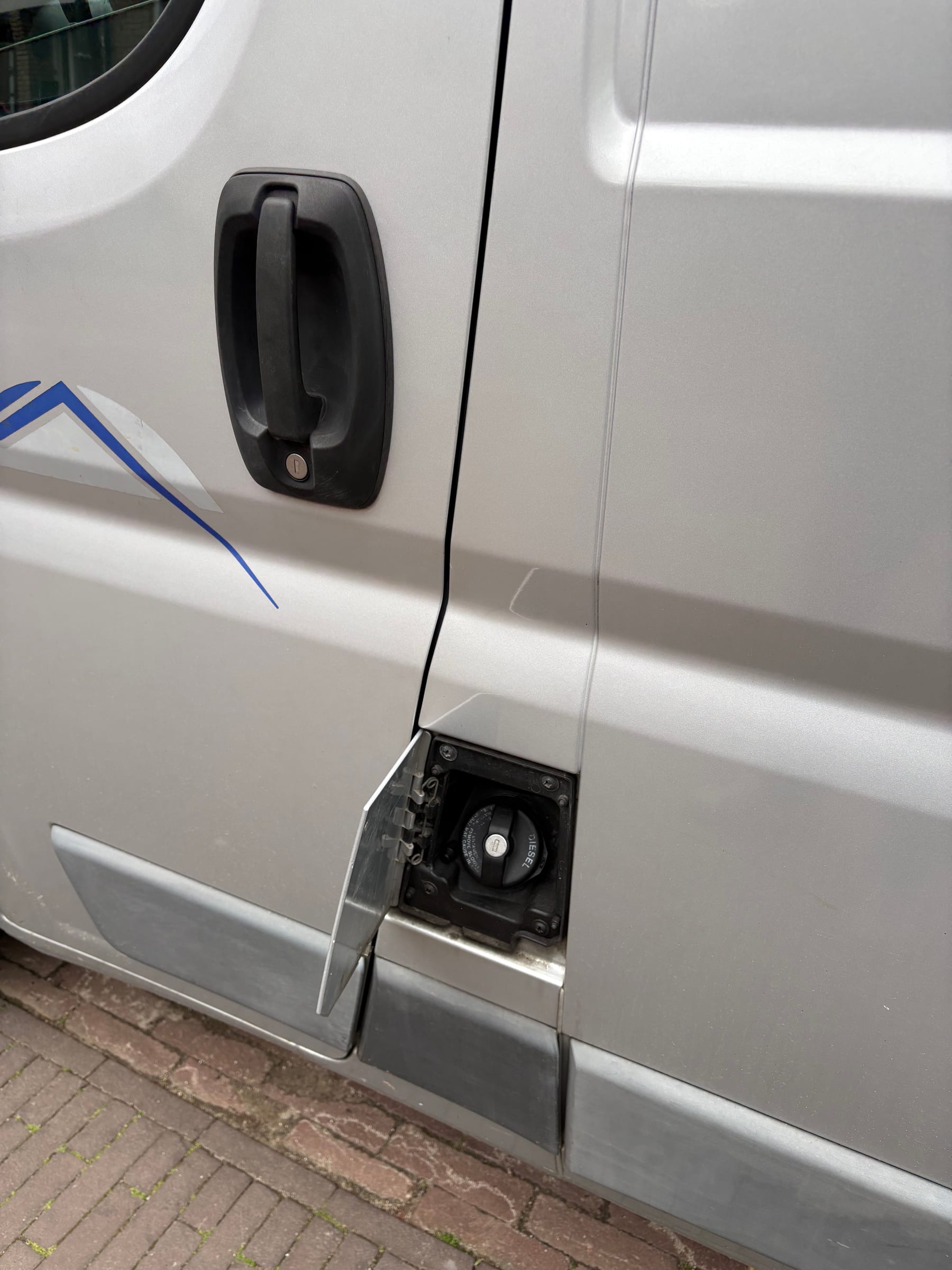 Dieseltankdop bij de bestuurdersdeur van de camper.