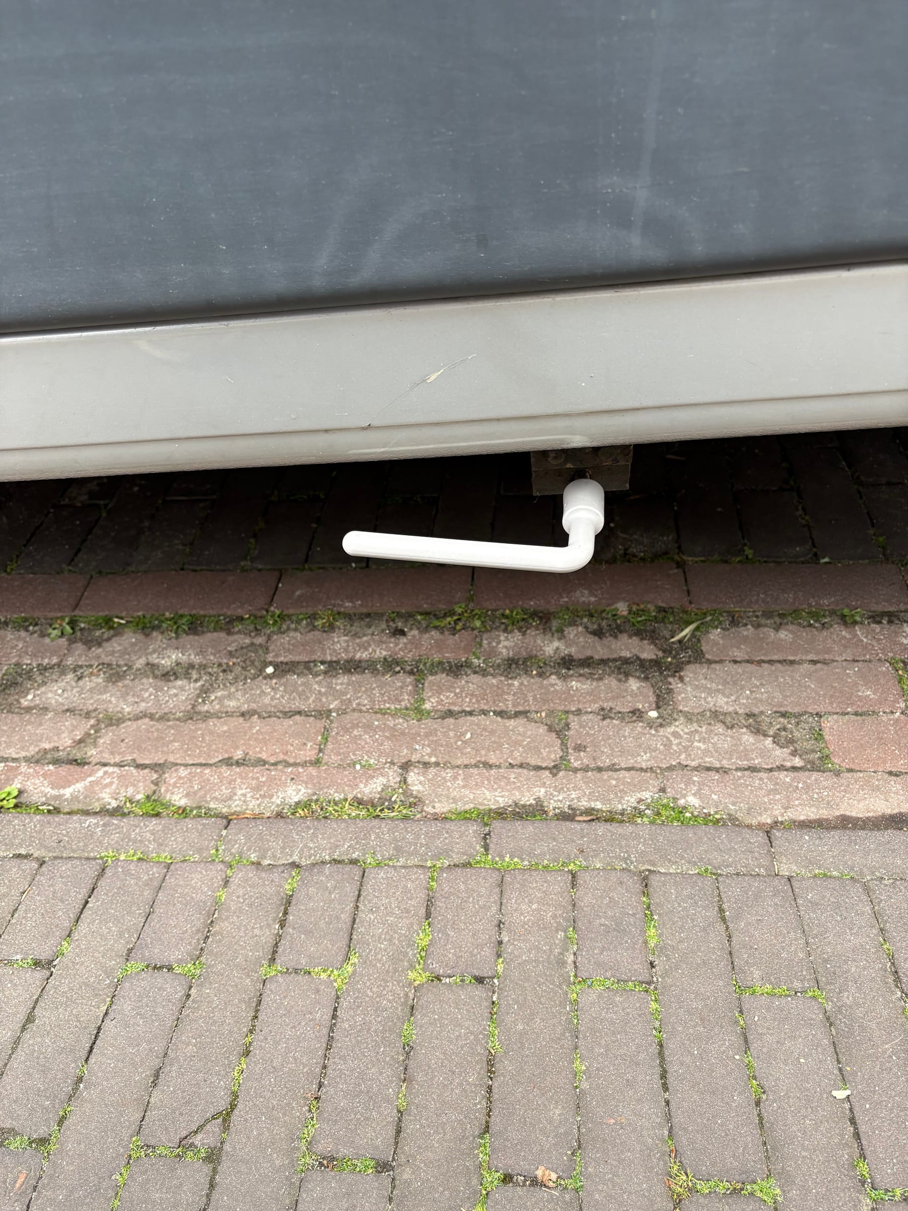 Sleutel op de vierkante aansluiting van de vuilwatertank.